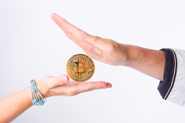Bitcoins, criptomonedas, dinero electrónico en manos hombre y mujer
