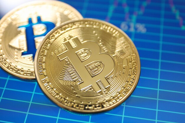 Bitcoins dourados na tela com negociação de finanças de gráfico