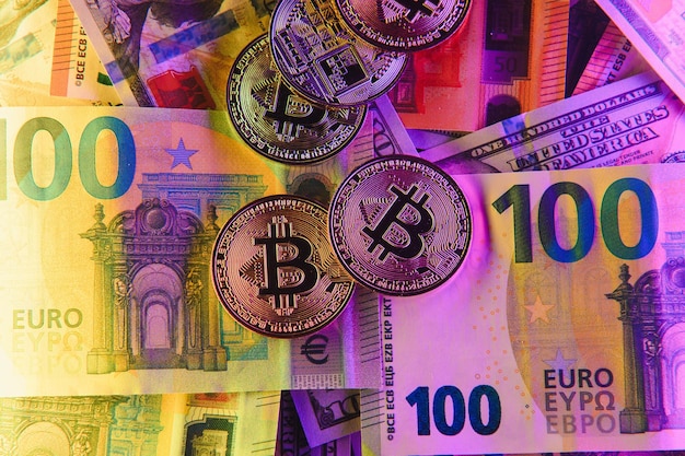 Bitcoins dourados nova moeda virtual com dólares tradicionais e euro como pano de fundo