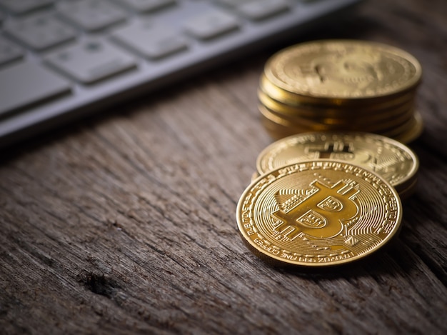 Bitcoins goldene Farbe auf der Tastatur und dem Arbeitstisch mit Nahansicht machen