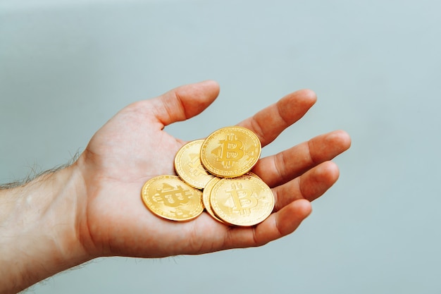 Bitcoins en mano sobre un fondo claro foto de alta calidad