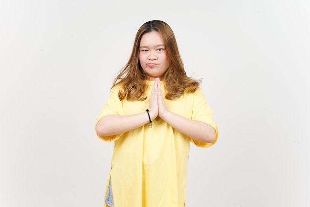 Bitte um Entschuldigung für die schöne asiatische Frau mit gelbem T-Shirt isoliert auf weißem Hintergrund