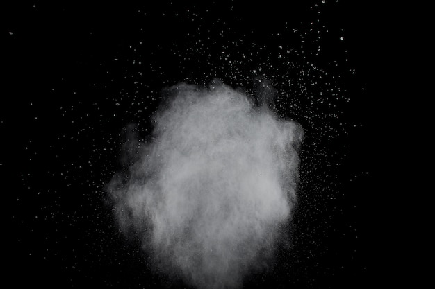 Bizarre Formen der Explosionwolke des weißen Pulvers gegen schwarzen Hintergrund. Weiße Staubpartikel spritzen.