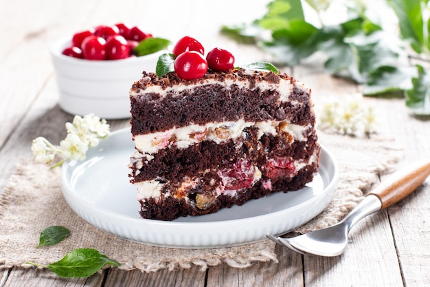 Bizcocho de chocolate con cerezas en un plato sobre una mesa de madera