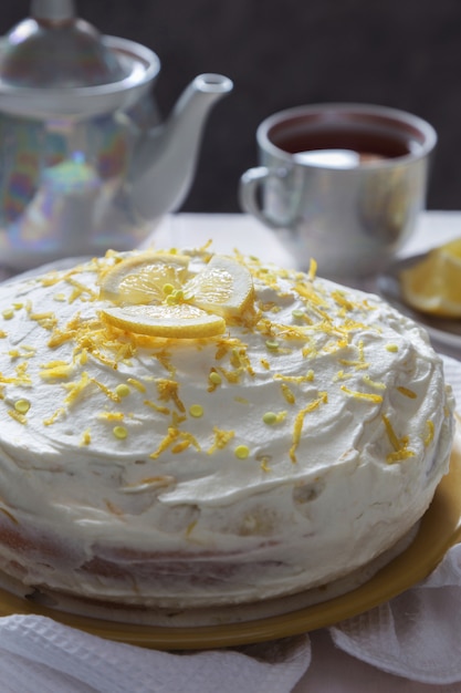 Foto bizcocho de limón con crema, ralladura y té