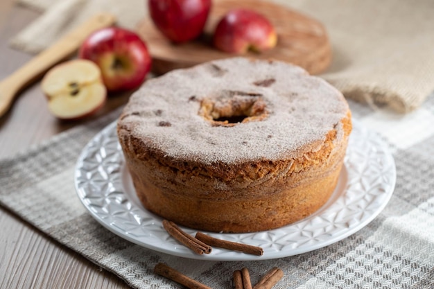 Bizcocho o bizcocho de gasa con manzanas tan suaves y deliciosas en rodajas con ingredientes canela huevos harina manzanas en mesa de madera Concepto de panadería casera para fondo y papel tapiz