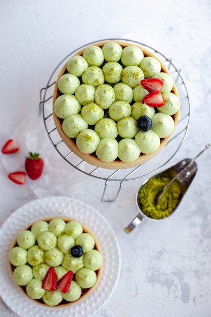 Foto bizcocho redondo con crema de pistacho verde y mermelada de fresa