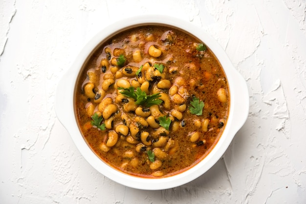 Black Eyed Beans Curry ou Chawli ou chavli chi usal ou masala, servido em uma tigela de cerâmica sobre um fundo sombrio, foco seletivo