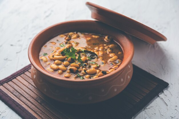 Black Eyed Kidney Beans Curry oder Chawli oder Chavli Chi Usal oder Masala, serviert in einer Keramikschale über stimmungsvollem Hintergrund, selektiver Fokus