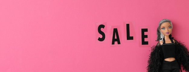 Foto black friday-konzept-shopaholic-puppe auf rosa hintergrund