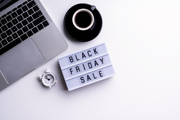 Black Friday Sale palavras em lightbox com xícara de café laptop e relógio vista superior plana sobre fundo branco