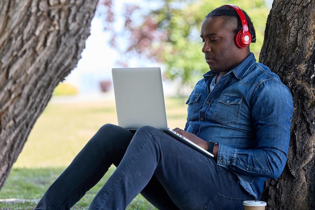 Black guy se está preparando para los exámenes escuchando conferencias de audio fuera del aula