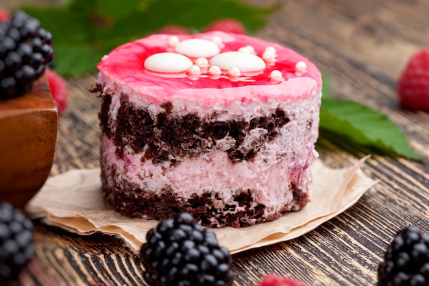 Blätterteig-Schokoladenkuchen mit Beerenfüllung aus Brombeeren und Erdbeeren, um den Kuchen Himbeeren und Brombeeren