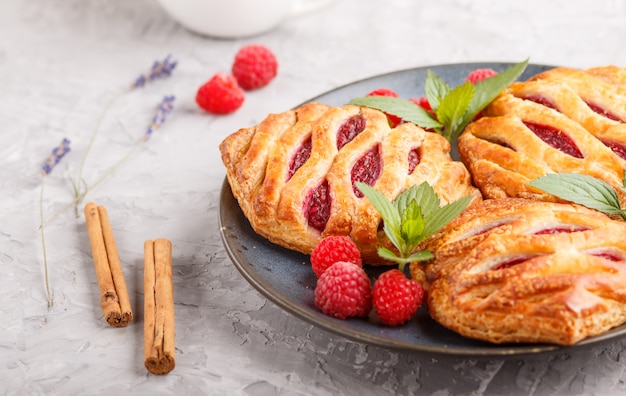 Blätterteigbrötchen mit Erdbeermarmelade auf blauer keramischer Platte