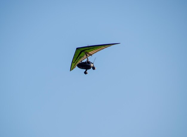 Foto blagoweschtschenskaja, russland, 8. juli 2018, trike fliegt mit zwei personen in den himmel, extreme unterhaltungsreisende, ein fliegender drachenflieger mit motor am himmel, unterhaltung von touristen auf dem meer