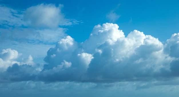 Blancas nubes esponjosas con arco iris en el cielo azul