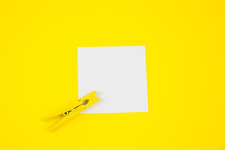 Foto blanco en blanco to do list sticker con pinza de madera amarilla primer plano de papel de nota de recordatorio sobre el fondo amarillo espacio de copia minimalismo foto original y creativa