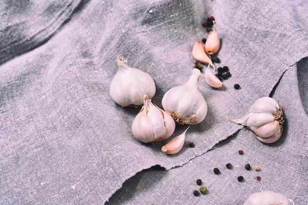 Blanco cabezas de ajo crudo en un paño gris, de cerca