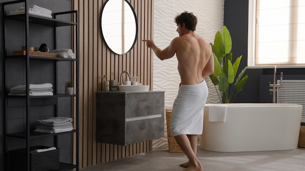 Foto blanco desnudo feliz juguetón alegre hombre desnudo sin camisa sexy hombre activo en el baño con toalla de baño
