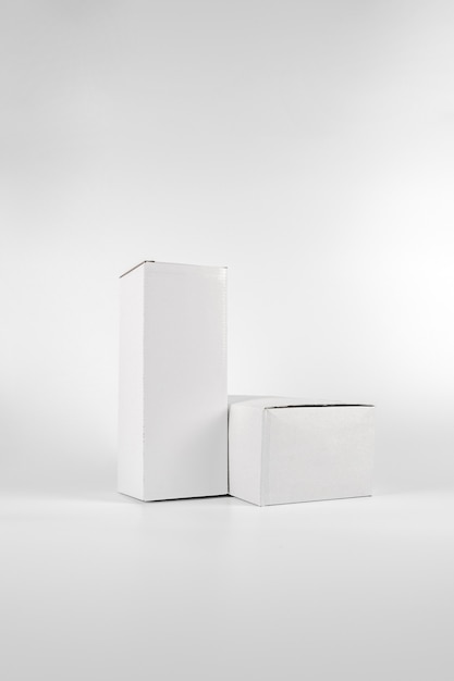 Blanco dos cajas de papel - alto y gordo yacía sobre el fondo blanco en una foto de estudio con paht de recorte.