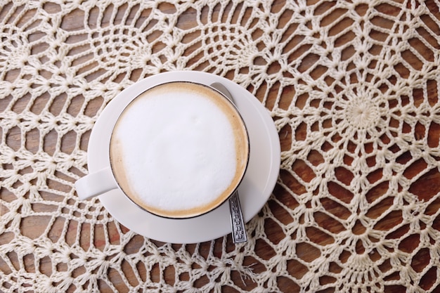 Blanco taza de café caliente en la mesa de madera