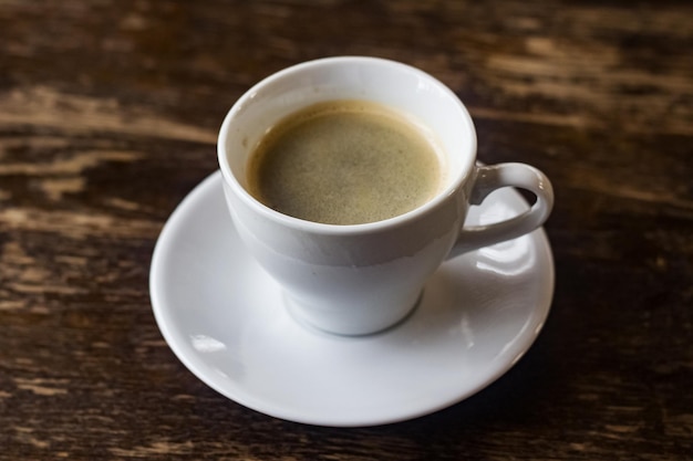 Blanco taza de café en una mesa de madera