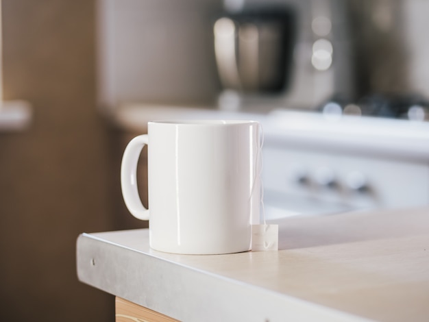 Blanco taza de té en la mesa de la cocina.