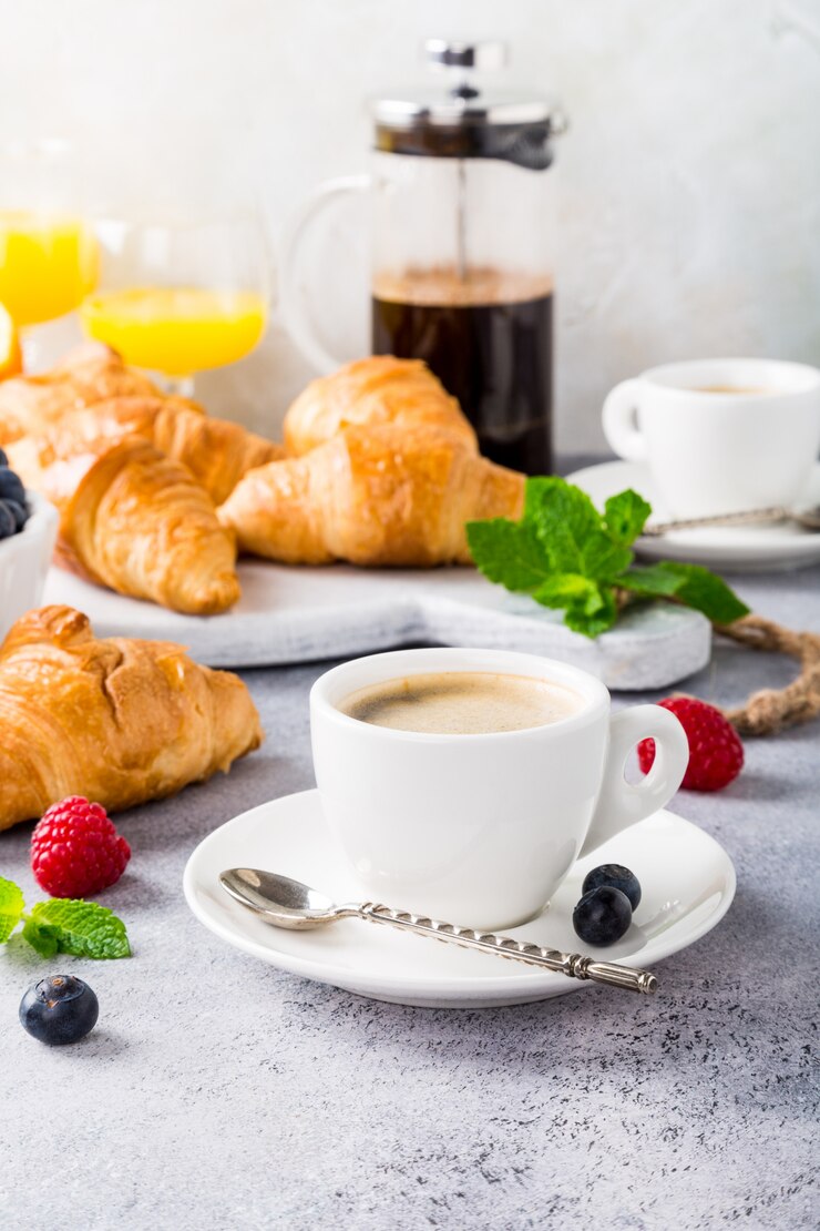 Blanco tazas de café y croissants.
