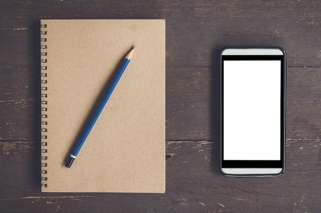 Blank notebook und telefon leere bildschirm für die werbung auf holz tisch hintergrund mit platz.