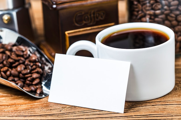 Blank Visitenkarten und Tasse Kaffee auf Holztisch. Corporate stationäre Branding Mock up.