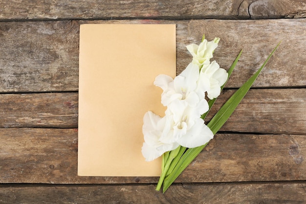 Blankokarte mit schöner Gladiole auf Holzuntergrund