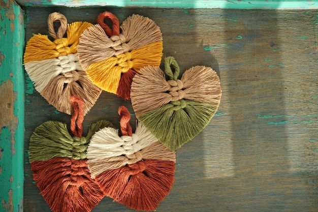 Foto blattmakramee mit bunten fäden auf holzboden.