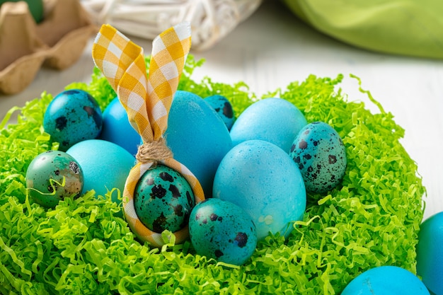Blau gemalte Eier in einem Nest für Ostern