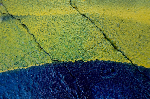 Blau und gelb gestrichener alter, grungy, rissiger, verwitterter Betonwandoberflächenstrukturhintergrund