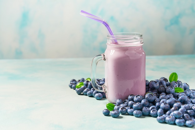 Blaubeer-Smoothie in einem Glas auf einem rustikalen Tisch.