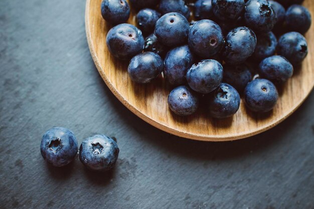 Blaubeeren auf dunklem Hintergrund auf einem Teller