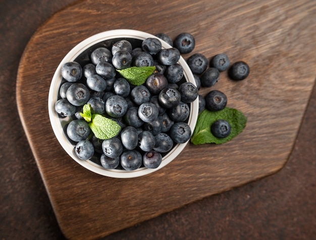 Blaubeeren auf einem Teller auf einem Holz. Reife und saftige frische Blaubeeren