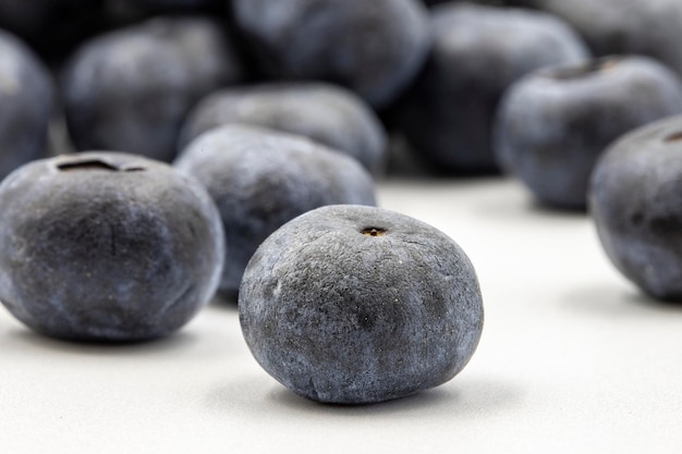 Blaubeeren auf weißem Hintergrund in Kombination mit dem Schatten reifer Blaubeeren aus der Nähe