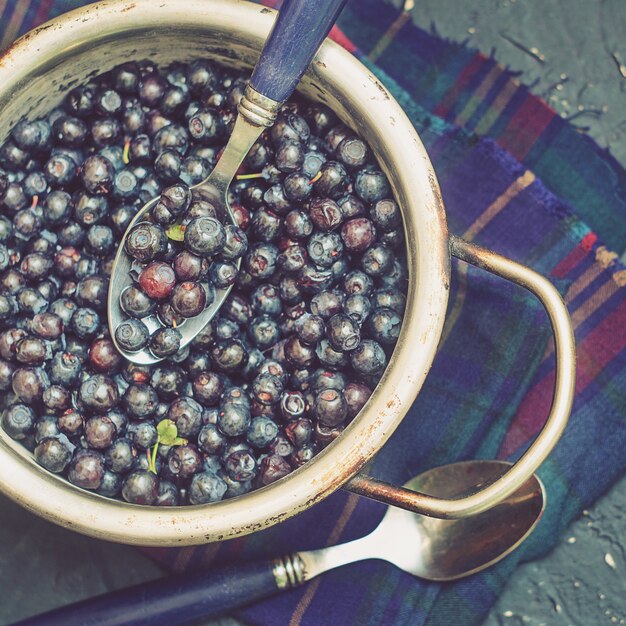 Blaubeeren in einer Metallschale auf dunklem Hintergrund