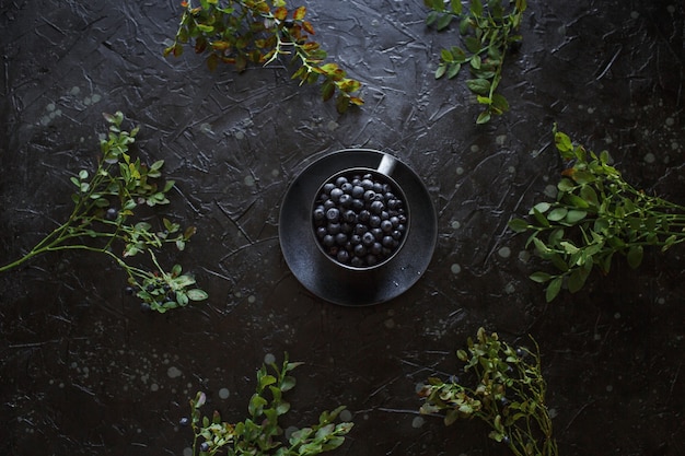 Foto blaubeeren in einer tasse, schwarzer hintergrund