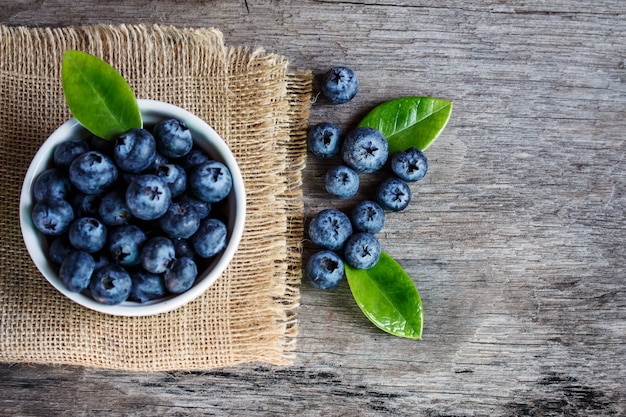 Blaubeeren in einer weißen Schüssel auf einem Holztisch