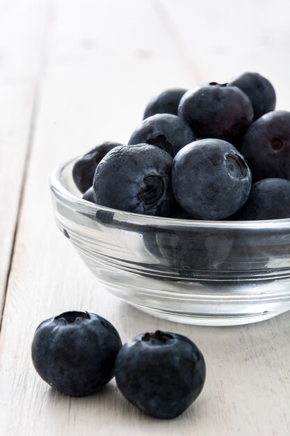 Blaubeeren in Kristallschale auf weißem Holz