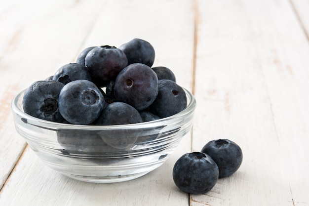 Blaubeeren in Kristallschale auf weißem Holz