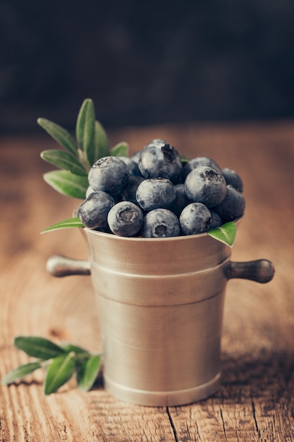 Blaubeeren in Metallschalen auf Holztisch