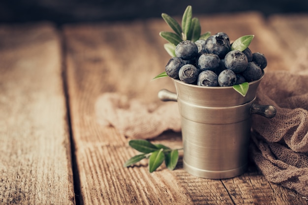 Blaubeeren in Metallschalen auf Holztisch