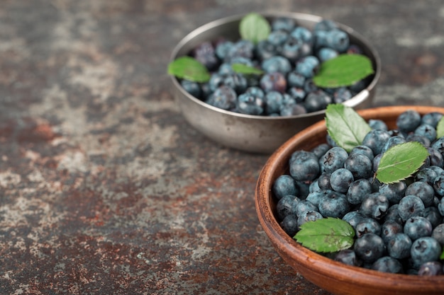 Blaubeeren in Schalen auf dunklem Hintergrund