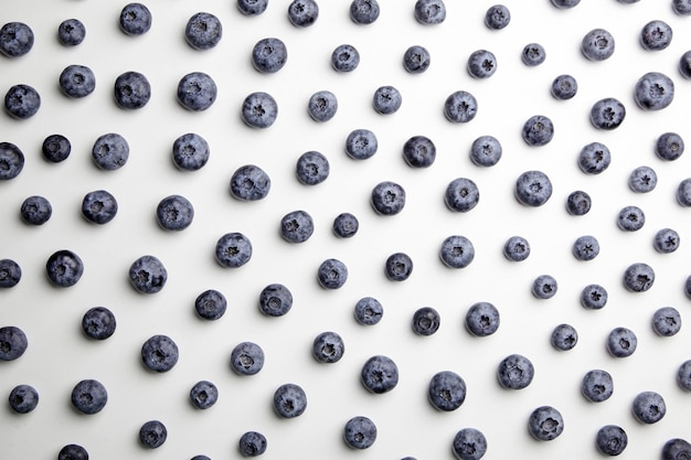 Blaubeeren mit Schatten auf weißer Tischplatte mit flachem Lay