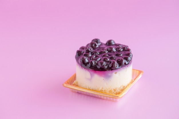 Blaubeerkäsekuchen auf einem rosa Hintergrund