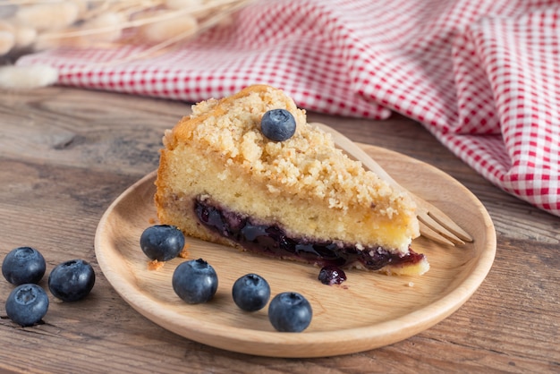 Blaubeerkuchen auf hölzerner Platte.