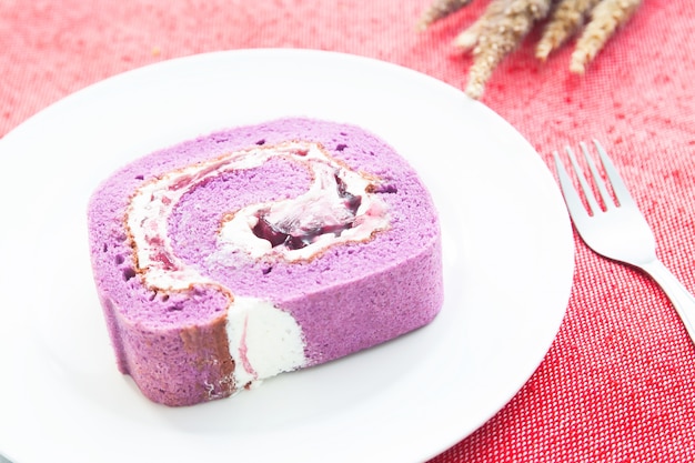 Blaubeerrollenkuchen auf weißer Platte